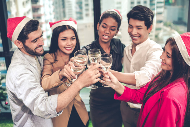 クリスマスと新年を祝うオフィスワーカーのトップビューグループには、クリンクグラスとワインを飲み、オフィスで幸せと笑顔があります。会社のパーティーのお祝いの概念. - 写真・画像