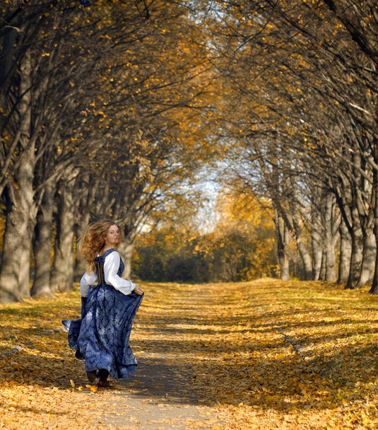 κορίτσι, ντυμένοι με ένα ρετρό στιλ τρέχω επάνω το φθινόπωρο σοκάκι - Φωτογραφία, εικόνα