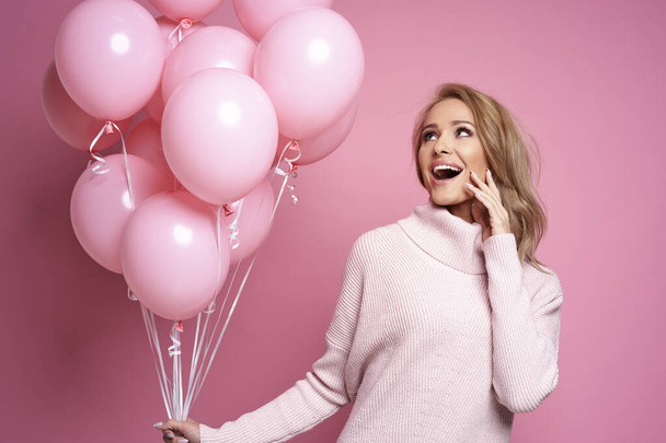 Alegre mujer caucásica sosteniendo enorme ramo de globos rosados  - Foto, imagen