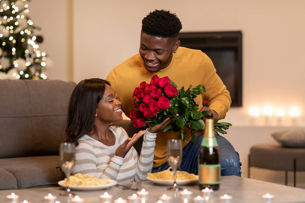 African Man Giving Flowers To Girlfriend Celebrating Valentine At Home - Photo, image