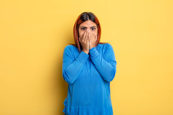 young hispanic woman feeling worried, upset and scared, covering mouth with hands, looking anxious and having messed up - Foto, Imagem