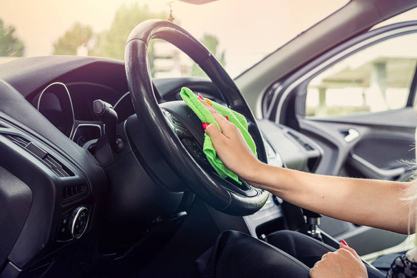 mani femminili tengono panno in microfibra e bottiglia spray per la pulizia auto all'interno, da vicino - Foto, immagini