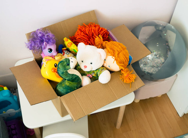 κουτί δωρεών με παιδικά παιχνίδια. παιχνίδια για φιλανθρωπικούς σκοπούς στο παιδικό δωμάτιο - Φωτογραφία, εικόνα
