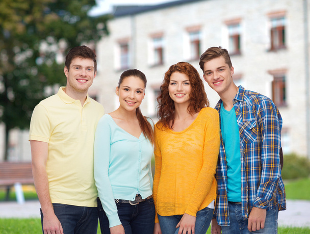 group of smiling teenagers over campus background - Zdjęcie, obraz
