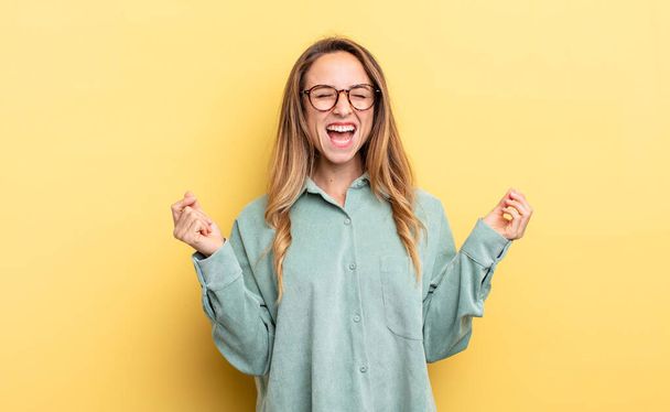 pretty caucasian woman looking extremely happy and surprised, celebrating success, shouting and jumping - Foto, afbeelding