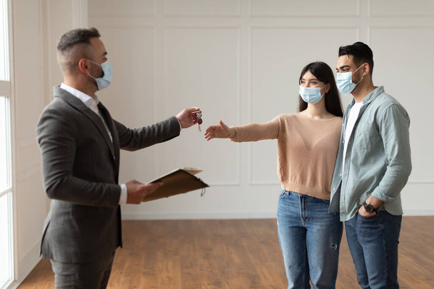 Real Estate Agent In Facemask Giving Keys To Excited Buyers - Photo, Image