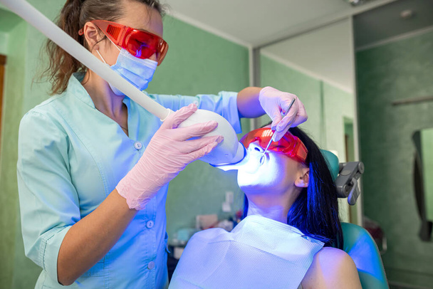 Dentista examinando os dentes do paciente com lâmpada UV de perto - Foto, Imagem