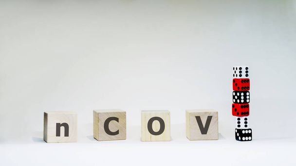 Word nCOV with wooden letters with six dices on white background. Coronavirus and COVID-19 concept. Chance to get sick. - Φωτογραφία, εικόνα