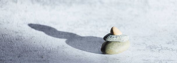 Banner theme of relaxation and meditation. Stones on gray background with space for copying. Balance and equilibrium. - 写真・画像