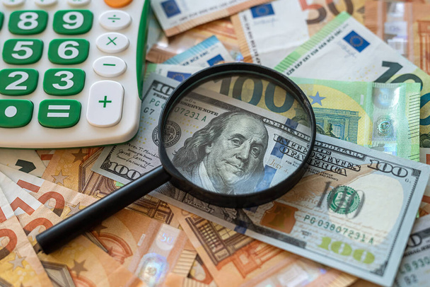 dollar and euro bills under magnifying glass. bribery or devaluation of money - Фото, зображення