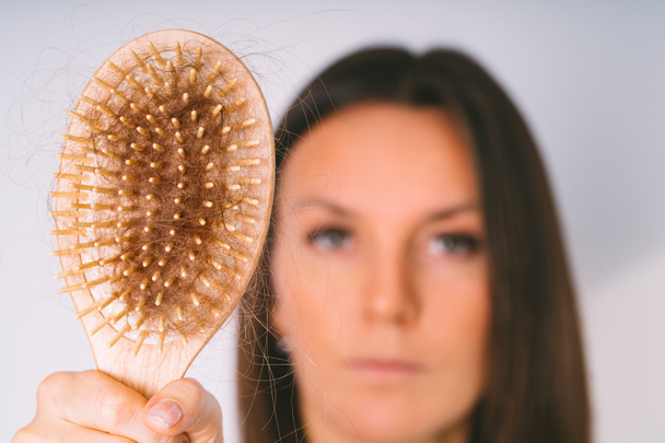 Woman showing hair brush with damaged hair. Hair loss problem. Bad hair falling out - Photo, Image