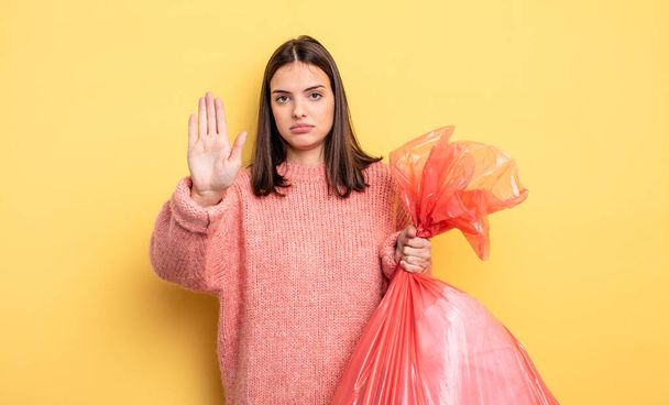 pretty woman looking serious showing open palm making stop gesture. trash bag concept - Fotografie, Obrázek