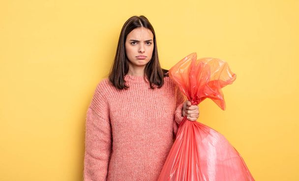 pretty woman feeling sad, upset or angry and looking to the side. trash bag concept - 写真・画像