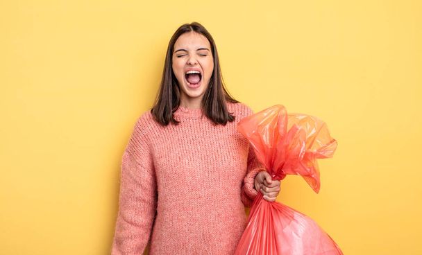 pretty woman shouting aggressively, looking very angry. trash bag concept - Fotoğraf, Görsel