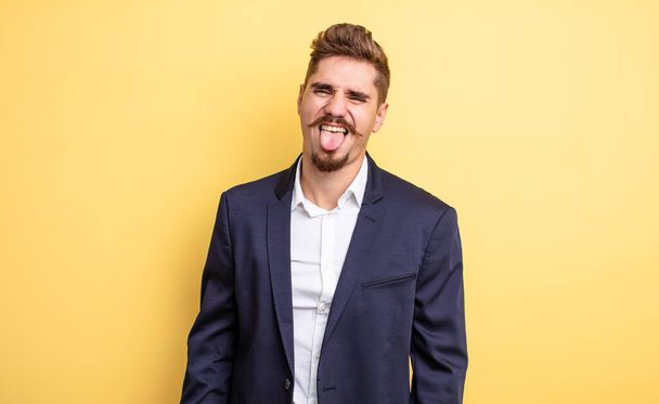 businessman with cheerful and rebellious attitude, joking and sticking tongue out - Foto, Bild