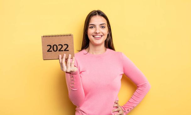 pretty woman smiling happily with a hand on hip and confident. 2022 calendar concept - Valokuva, kuva