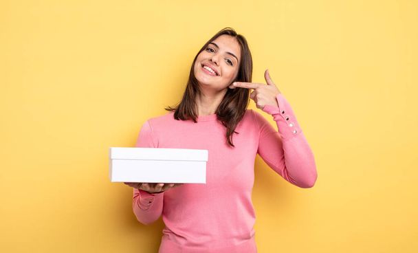 pretty woman smiling confidently pointing to own broad smile. white box packaging concept - Foto, Bild