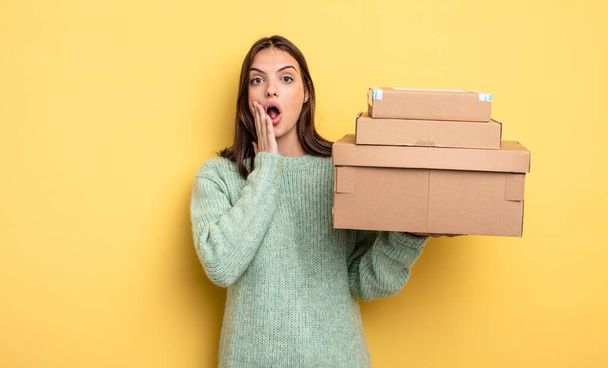 pretty woman feeling shocked and scared packages boxes concept - Foto, afbeelding
