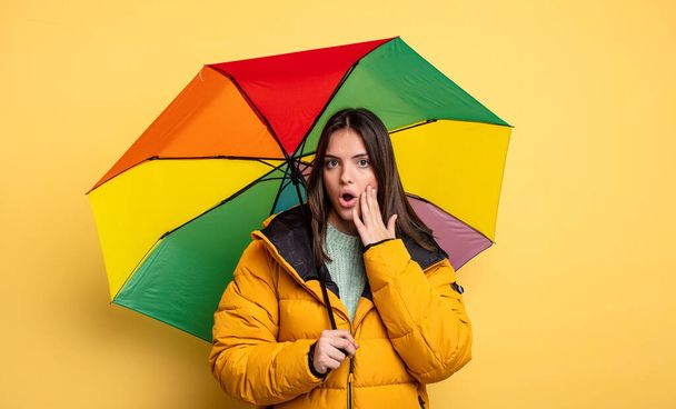 pretty woman feeling shocked and scared. winter and umbrella concept - Φωτογραφία, εικόνα
