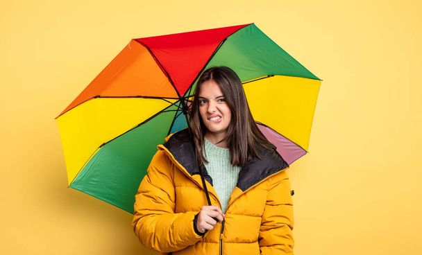 pretty woman looking puzzled and confused. winter and umbrella concept - Foto, imagen