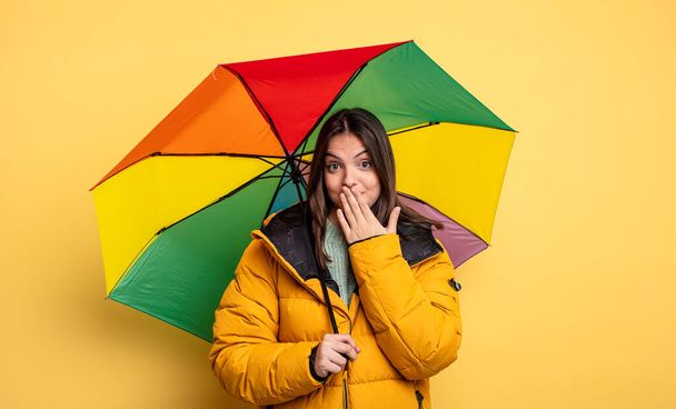 pretty woman covering mouth with hands with a shocked. winter and umbrella concept - Fotografie, Obrázek
