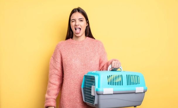 pretty woman with cheerful and rebellious attitude, joking and sticking tongue out. pet carrier concept - Foto, Imagen