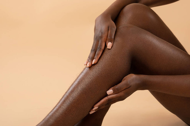 Cropped of african american woman touching her hairy legs - Фото, изображение