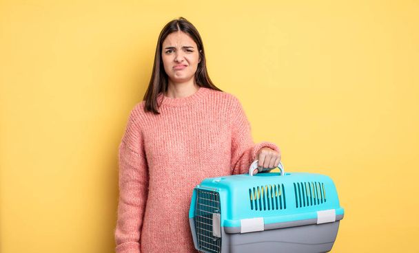 pretty woman looking puzzled and confused. pet carrier concept - Foto, Imagen