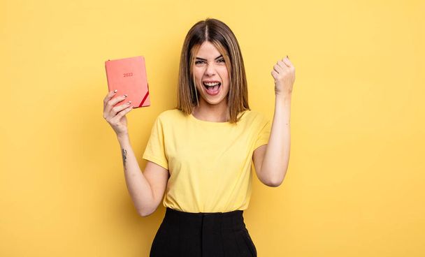 pretty woman shouting aggressively with an angry expression. planner concept - Fotoğraf, Görsel