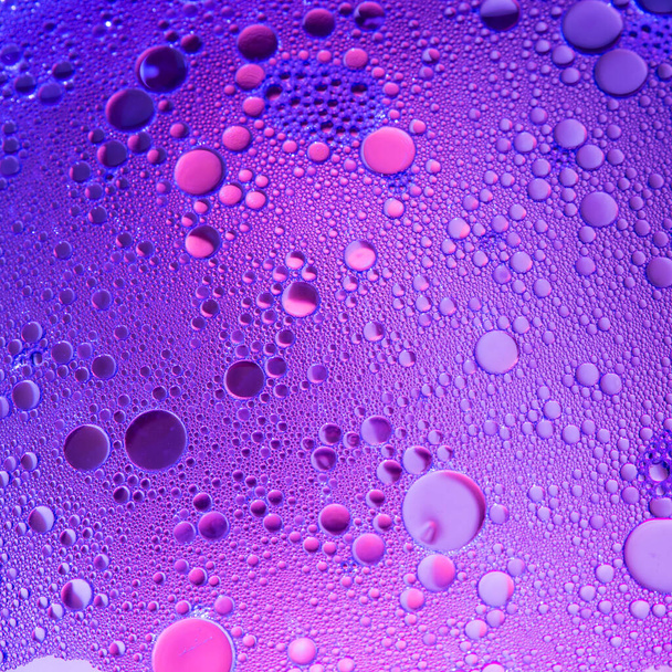 Lilac oil bubbles on water, abstract background - Foto, Imagen