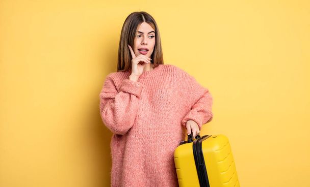 pretty woman smiling with a happy, confident expression with hand on chin. suitcase travel concept - Foto, Bild