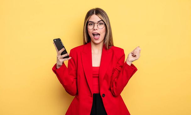 businesswoman feeling shocked,laughing and celebrating success. smartphone concept - Zdjęcie, obraz