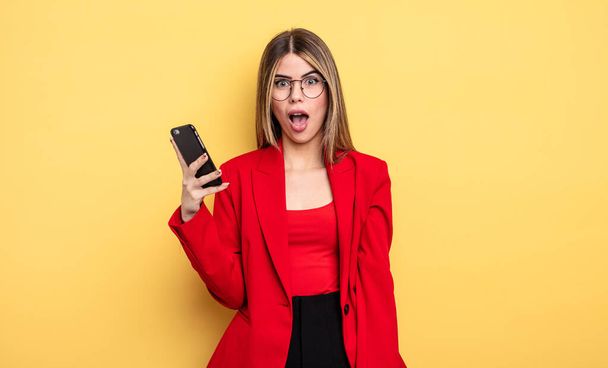 businesswoman looking very shocked or surprised. smartphone concept - Photo, image