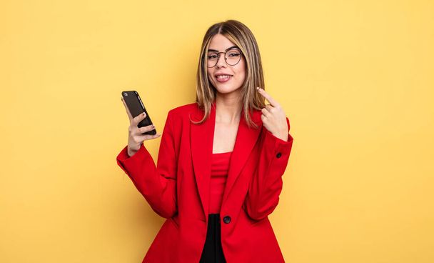 businesswoman smiling confidently pointing to own broad smile. smartphone concept - Foto, Bild