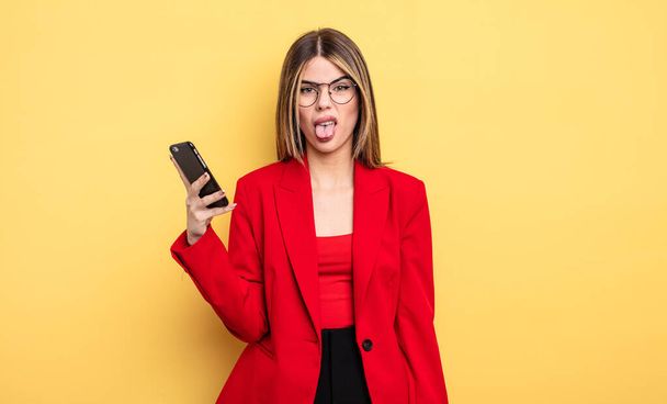 businesswoman feeling disgusted and irritated and tongue out. smartphone concept - Foto, Bild