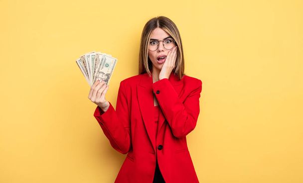 businesswoman feeling shocked and scared. dollar banknotes concept - Photo, image