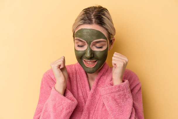 Young caucasian woman wearing face mask isolated on yellow background - Foto, Imagem