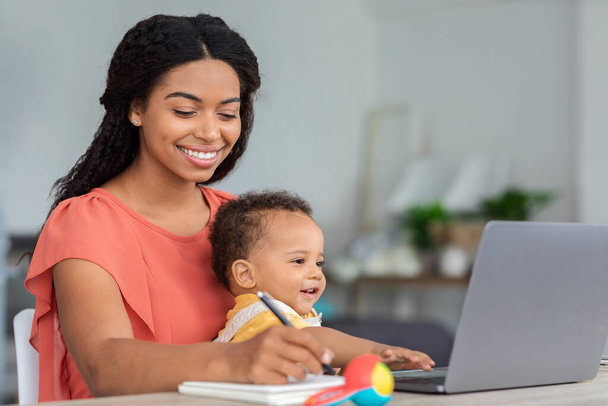 Motherhood And Education. Young Black Woman With Baby On Hands Study Online - Zdjęcie, obraz