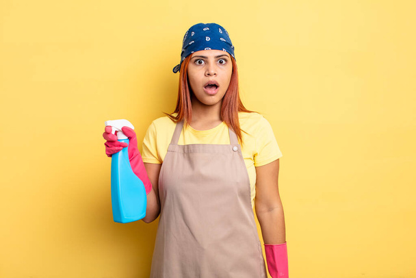 hispanic woman looking very shocked or surprised. cleaning and housekeeper concept - Photo, image