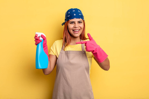 hispanic woman looking excited and surprised pointing to the side. cleaning and housekeeper concept - Фото, зображення