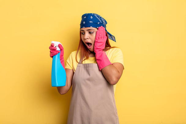 hispanic woman feeling happy, excited and surprised. cleaning and housekeeper concept - Foto, afbeelding