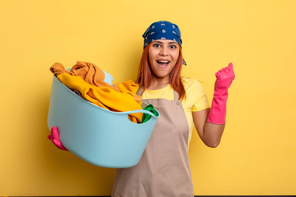 housekeeper feeling shocked,laughing and celebrating success. washing clothes concept - 写真・画像