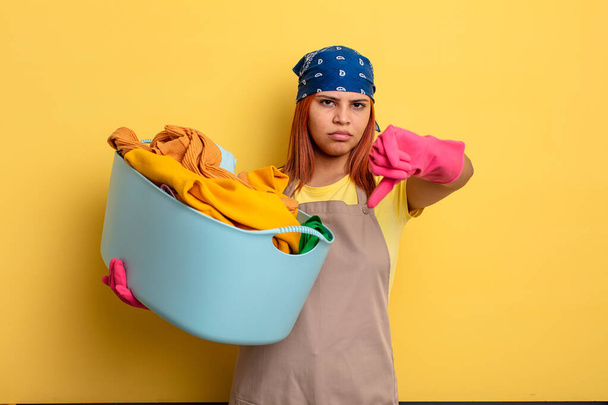 housekeeper feeling cross,showing thumbs down. washing clothes concept - Photo, Image