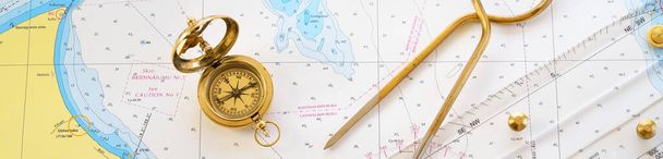 Retro stijl gouden kompas (zonnewijzer), antieke vintage W & HC 6 "messing verdelers schuifmaten nautische navigatie kaart gereedschap, parallelle liniaal, oude witte kaart close-up. Vintage stilleven. Zeilaccessoires - Foto, afbeelding