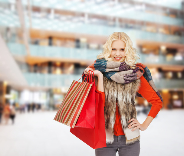 smiling young woman with red shopping bags - Foto, Imagen