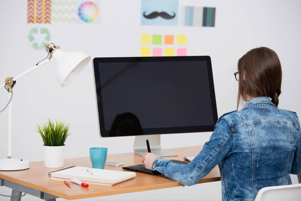 Woman working at desk In a creative office, using a computer  - Φωτογραφία, εικόνα