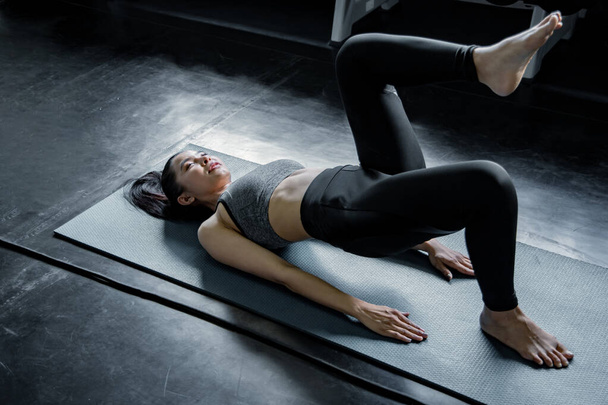 Seksowna Azjatka grająca w jogę na siłowni. Koncepcja ćwiczeń na siłowni. Kobieta trening jogi na macie. - Zdjęcie, obraz