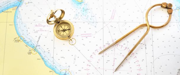Retro stílusú arany iránytű (napóra), antik vintage W & HC 6 "sárgaréz elválasztó fogantyúk hajózási navigációs térkép eszköz és régi fehér térkép közelkép. Vintage csendélet. Vitorlás tartozékok - Fotó, kép