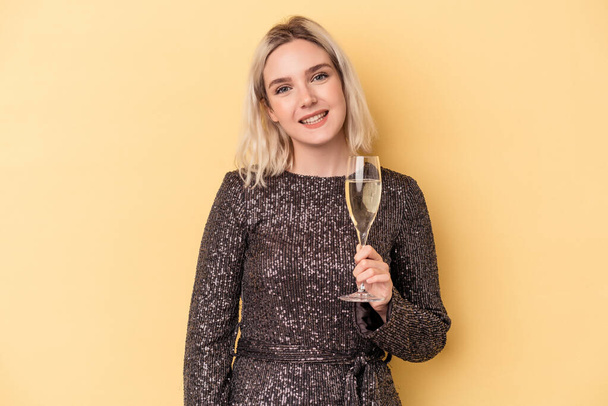 Young caucasian woman celebrating new year isolated on yellow background happy, smiling and cheerful. - Фото, изображение