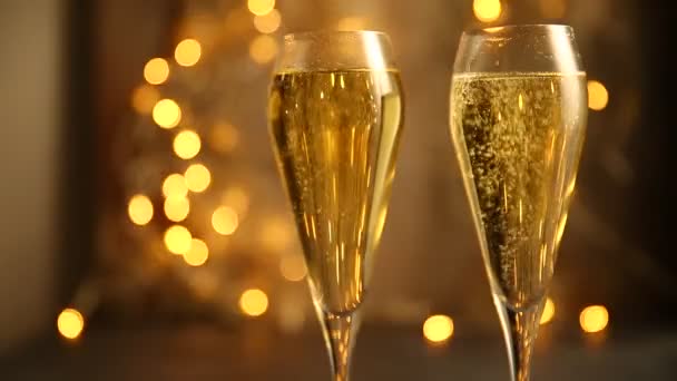 Two glasses of champagne against the background of lights. Selective focus. - Video